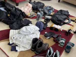 Hiking gear laid out on a rug.